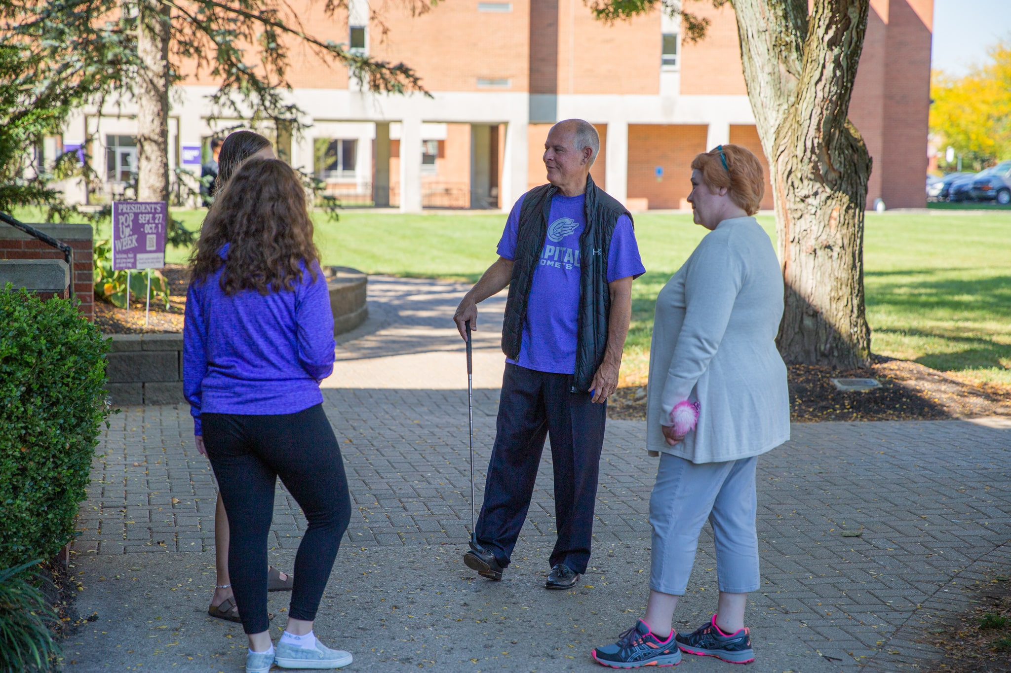 President Kaufman Talking To Students Playing Putt Putt