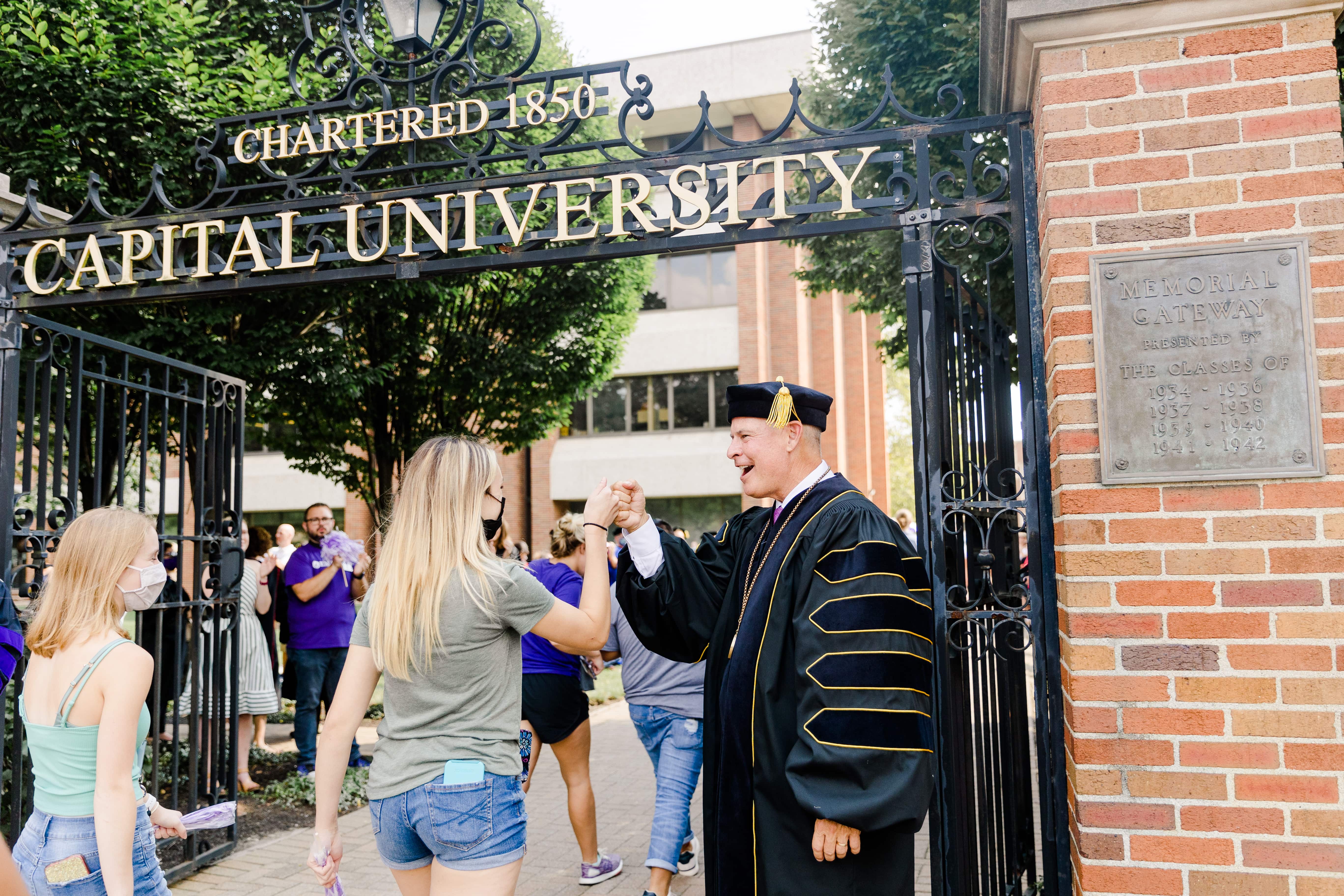 President Kaufman Fist Bumping Student At Gate