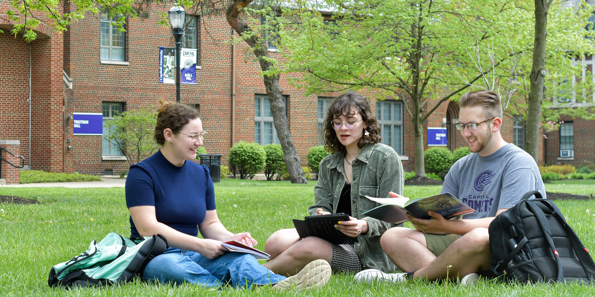 Students Sitting On Lawn In Quad (1)