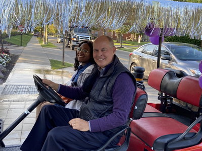 President Kaufman Driving Golf Cart With Bree Chambers